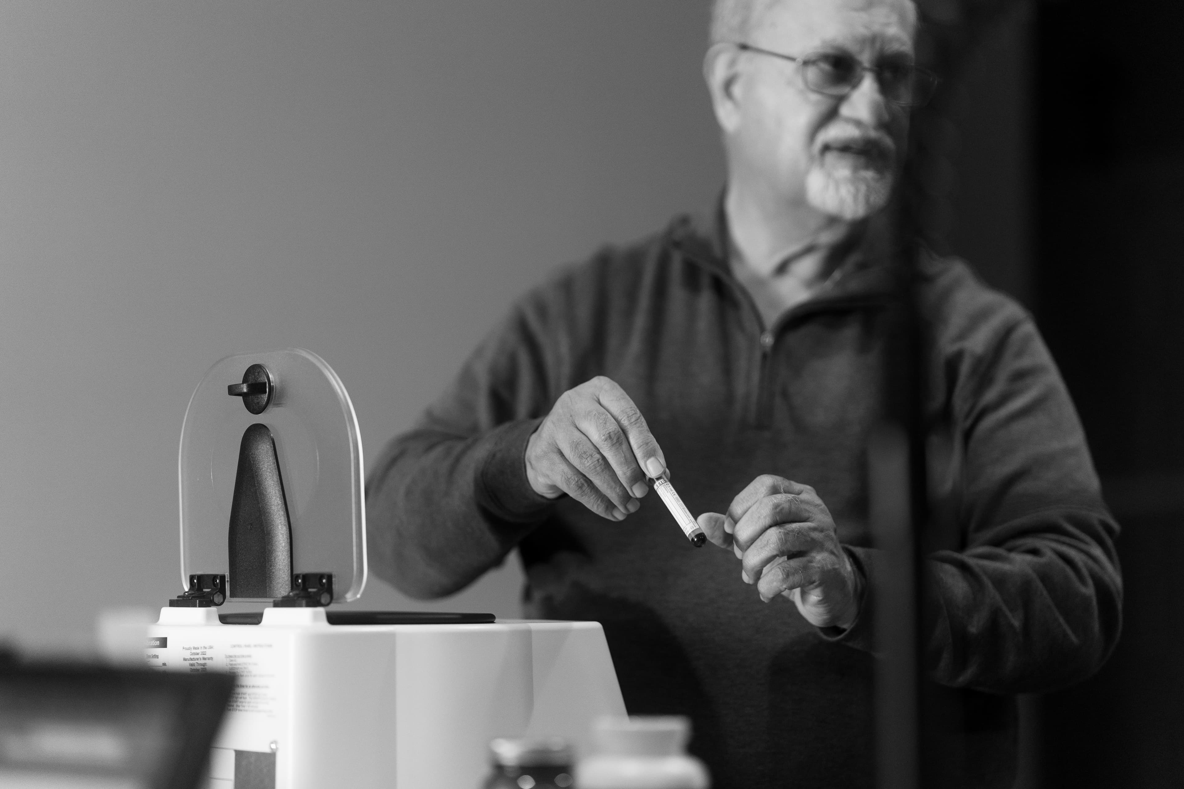 Dr. Khanna explaining to the owner how the test will be run and how much blood is required. Photo in black and white.